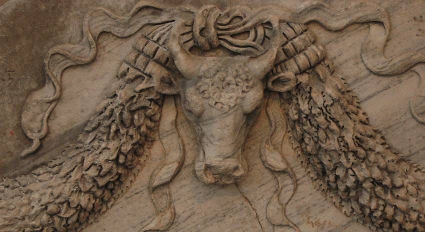 Carved marble relief of a bull's skull flanked by fruit garlands and trailing ribbons