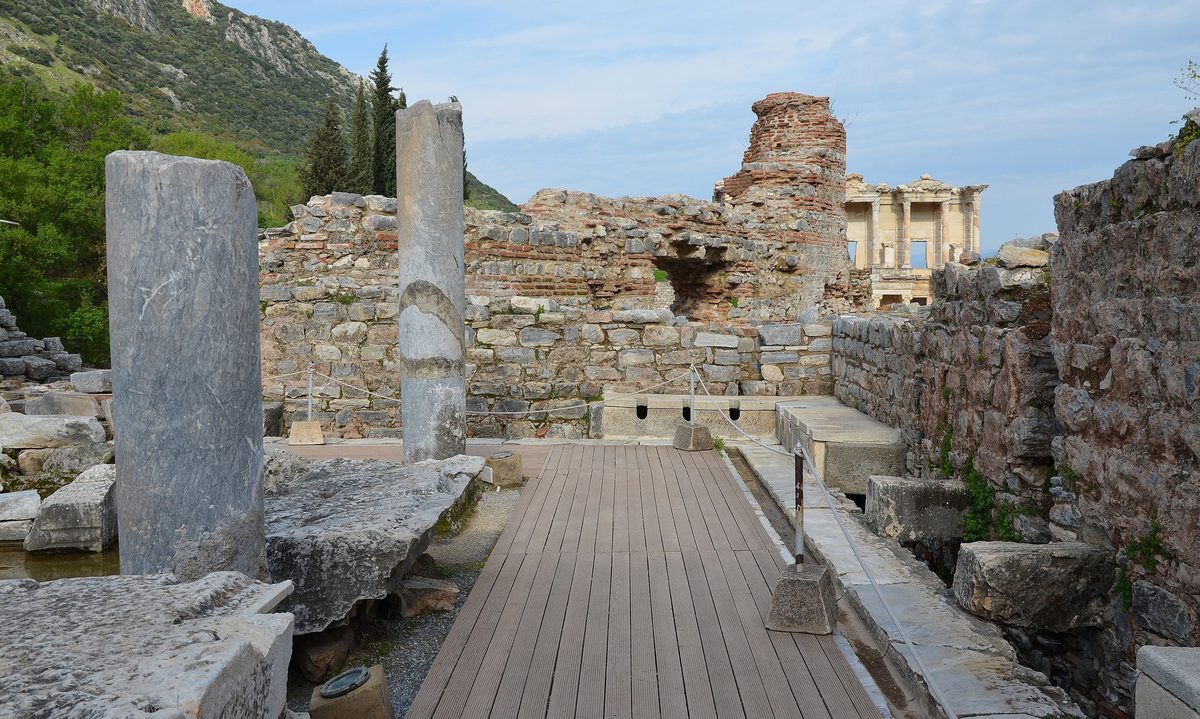The Library of Celsus at Ephesus seen down the walkway past the marble seats of the ancient public latrines.