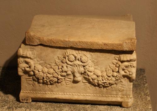 Small marble funerary chest with a carved garland and animal-head corners