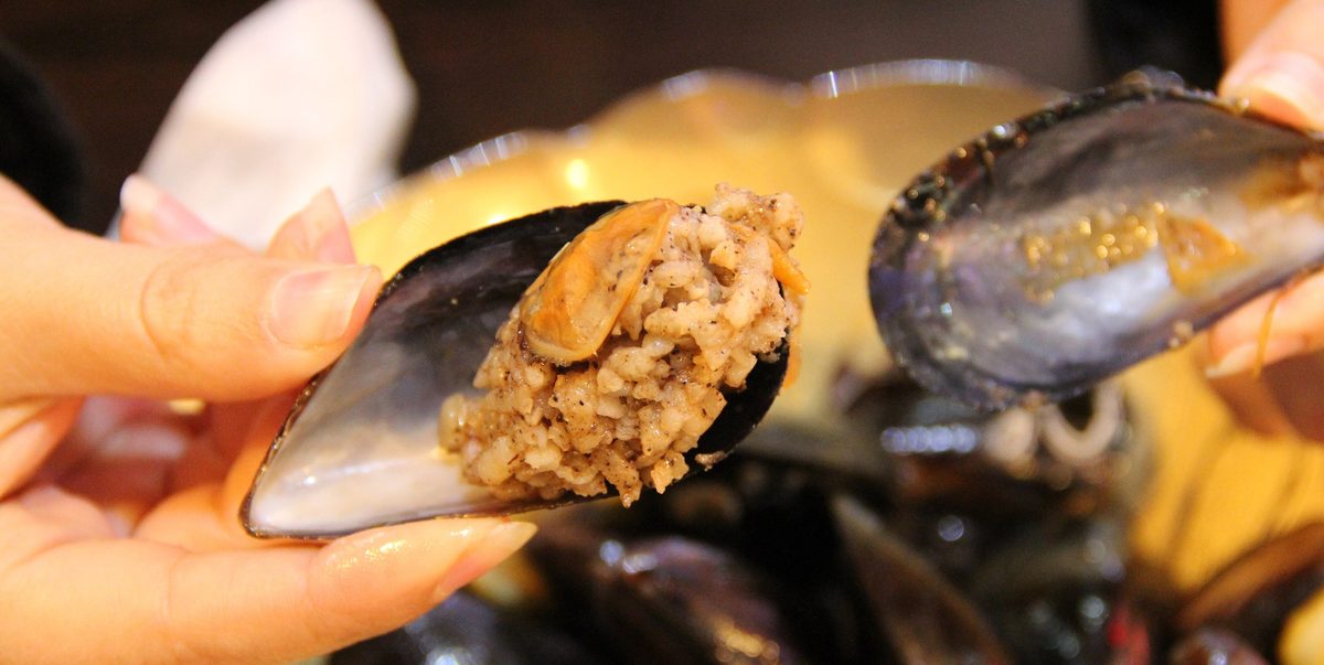 A chilled tray of mussels with lemons at a Kusadasi midye dolma stand