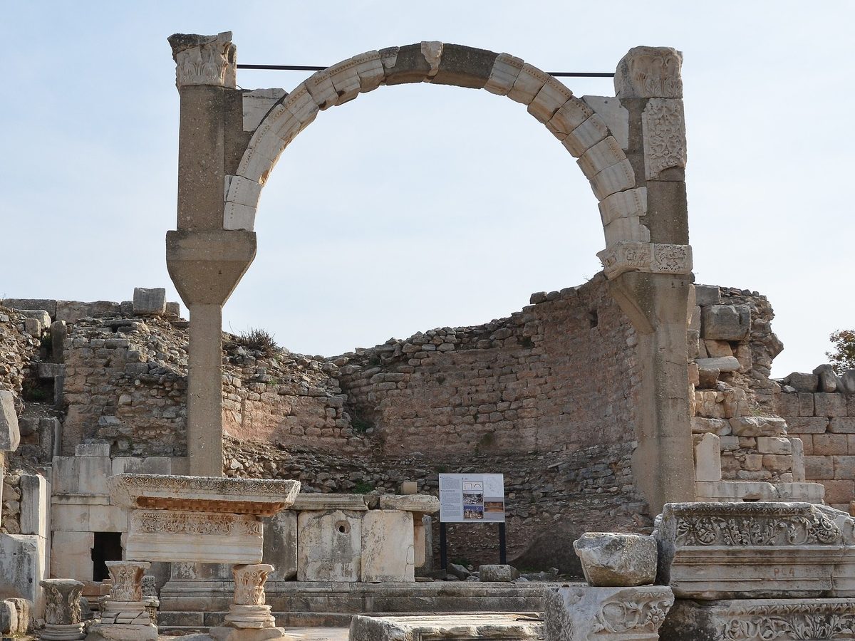 The Pollio Fountain at Ephesus seen from Domitian Square: one tall arch in front of a curved rubble apse, with carved marble blocks at its foot