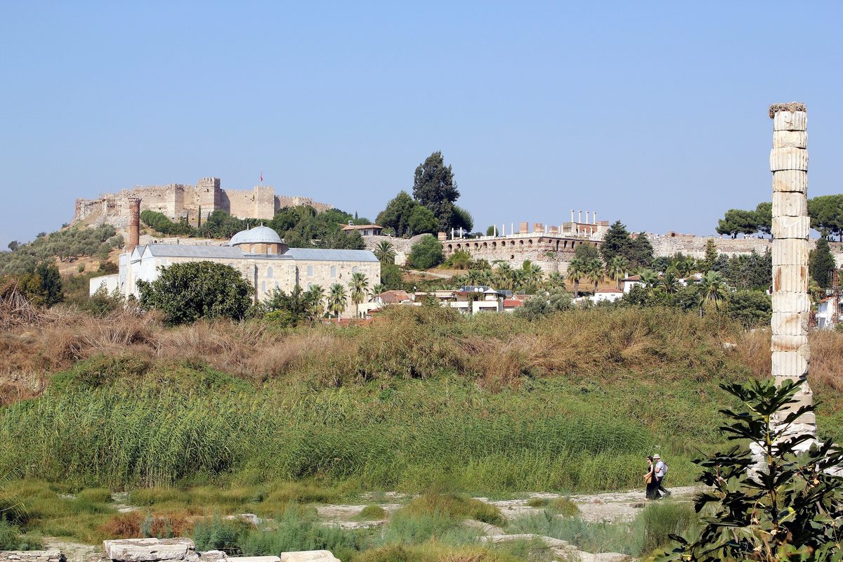 The single re-erected column of the Temple of Artemis in Selcuk, with the Isa Bey Mosque, the Basilica of Saint John and Ayasuluk Fortress on the hill behind