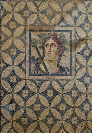 Roman mosaic panel of a youthful Dionysus wearing a grape and ivy wreath and holding a thyrsus staff.