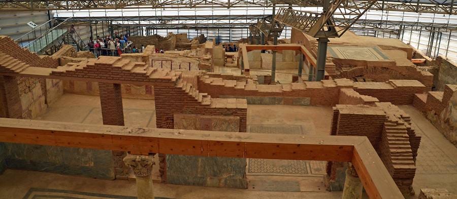 Excavated Roman houses with mosaic floors beneath the modern protective canopy at Ephesus