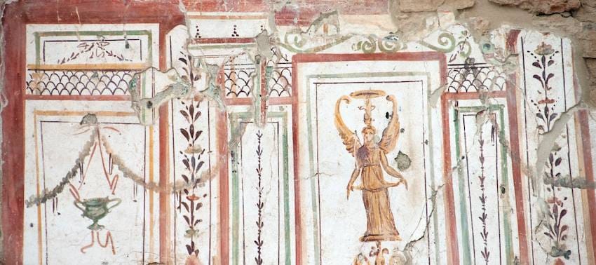 Roman wall fresco in the Terrace Houses of Ephesus with a winged figure painted between red and green panel borders.