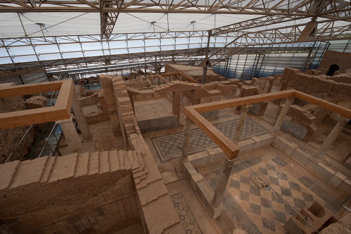 The steel and fabric roof over the Terrace Houses at Ephesus, with mosaic floors and brick walls in the shade below